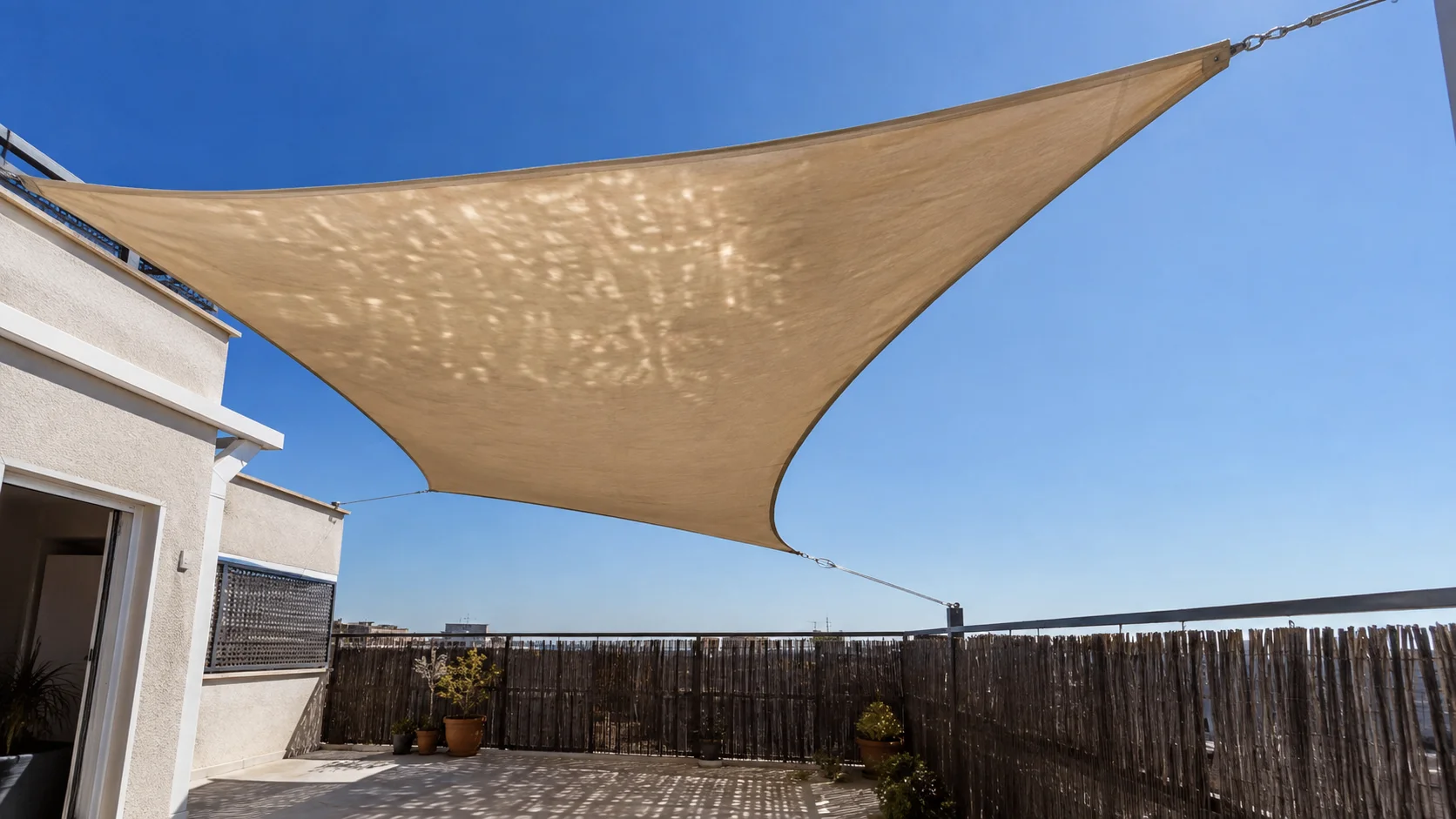 Vela de sombra tensada sobre una terraza para cortar el sol del mediodía